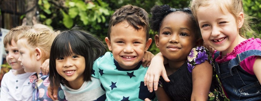 A group of pre-school children smiling.