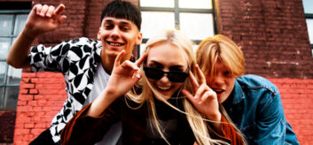 Three young people, smiling and looking into the camera.