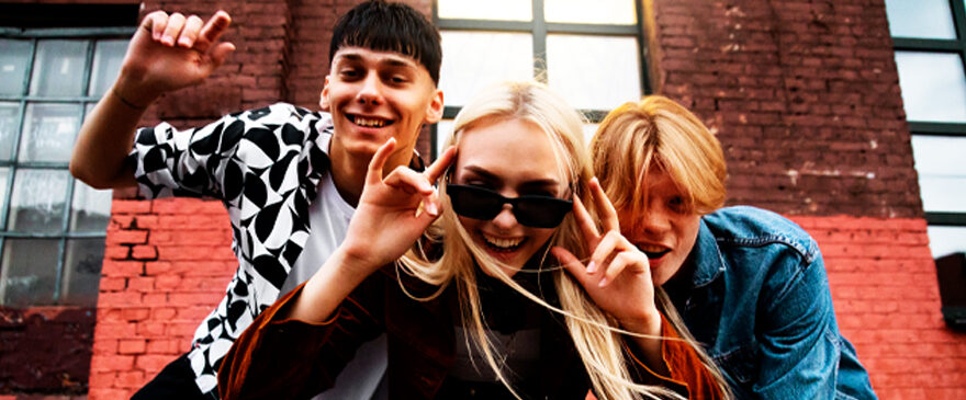 Three young people, smiling and looking into the camera.